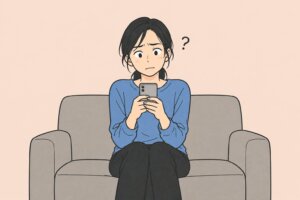結婚の決め手がわからず、ソファでスマホを見つめて迷う女性